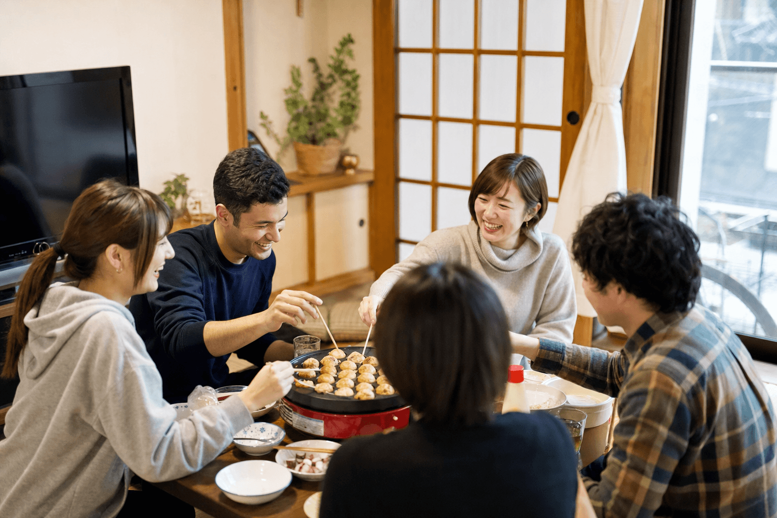 たこ焼きを囲んで談笑する集まりの様子